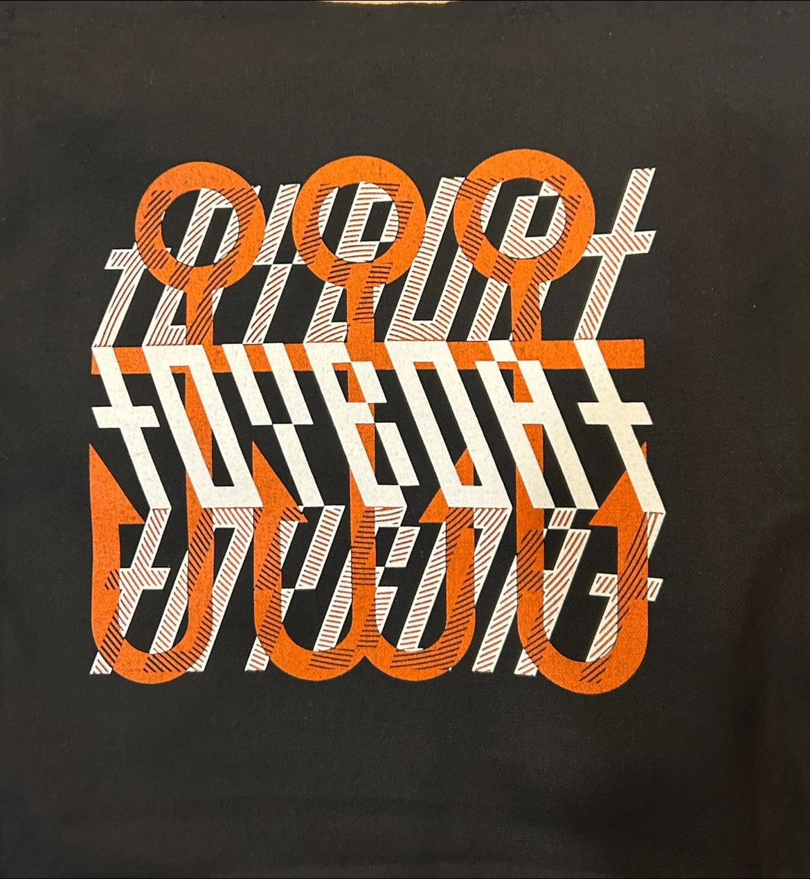 a black tote bag with orange letters on it